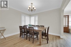 Dining space with a chandelier, baseboards, crown molding, and light wood finished floors - 