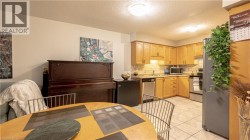Kitchen featuring appliances with stainless steel finishes, a sink, light countertops, light brown cabinets, and backsplash - 
