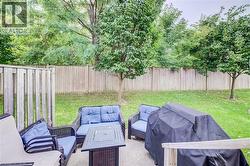 Private backyard featuring a fenced perimeter, mature trees, and a concrete patio area - 