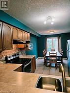 Kitchen featuring wood cabinetry, stainless steel sink, tile backsplash, and tile flooring - 