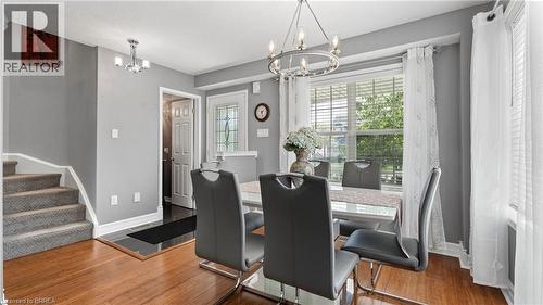 Hardwood-finish flooring, carpeted staircase, chandelier lighting, and a window with blinds - 124 Osborn Avenue, Brantford, ON 