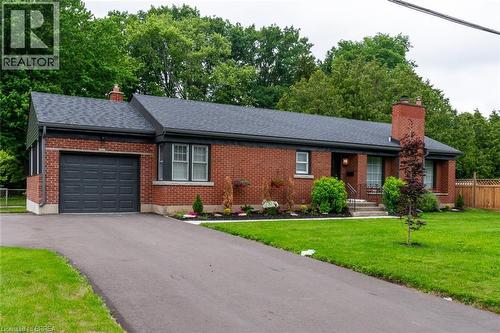 Brick exterior with dark shingle roof and integrated garage - 30 Proctor Avenue, Brantford, ON 