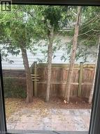 Private fenced backyard with mature trees and a paved patio - 