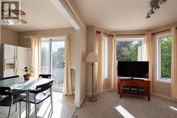Open concept living area with a bay window, track lighting, and a ceiling fan - 