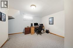 Carpeted room with white walls, wood trim, and a flush-mount ceiling light fixture - 