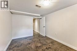 Interior room featuring a concrete floor, white walls, and a white door with a round knob - 