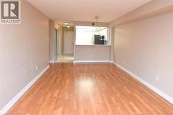 Laminate wood flooring throughout, light neutral wall paint, and a pass-through window with a breakfast bar - 