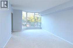 Expansive room featuring a bay window, wall-to-wall carpeting, and a mirrored sliding closet door - 