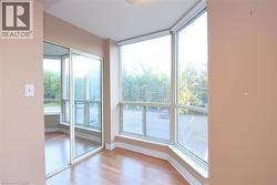 Bay window with multiple large panes, laminate wood flooring, white baseboards, and mirrored sliding closet doors - 
