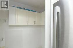 White wall-mounted cabinetry with brushed nickel hardware - 