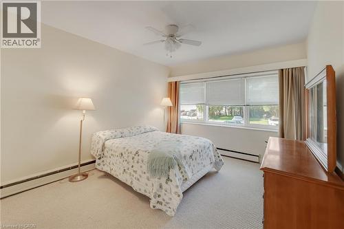 Wall-to-wall carpeting, multiple windows with blinds, ceiling fan, and baseboard heating - 824 Brant Street Unit# 9, Burlington, ON 