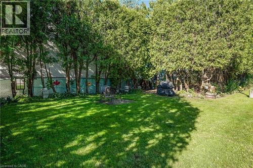 Expansive lawn area surrounded by mature trees and privacy fencing - 824 Brant Street Unit# 9, Burlington, ON 