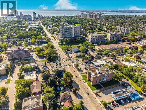 Aerial perspective of an urban landscape featuring a prominent waterway, multiple high-rise buildings, and extensive tree canopy - 824 Brant Street Unit# 9, Burlington, ON 