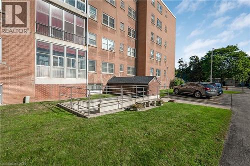 Brick exterior building with multiple windows, featuring a ground-level access ramp with metal railings - 824 Brant Street Unit# 9, Burlington, ON 