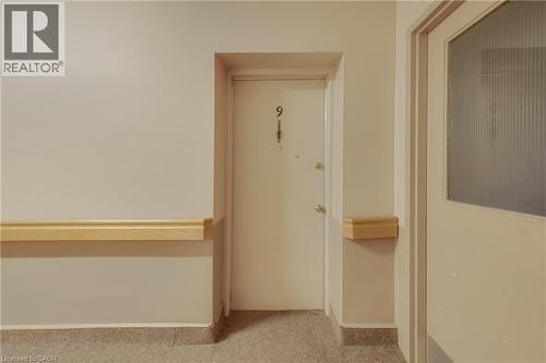 Entry door with brass hardware and visible unit number - 824 Brant Street Unit# 9, Burlington, ON 