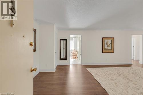Vaulted ceiling with crown molding, wood-finish flooring, and white painted walls - 824 Brant Street Unit# 9, Burlington, ON 