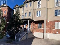 Brick and siding exterior featuring multiple windows with grilles and a covered entry - 