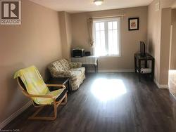 Wood-finish flooring with neutral wall tones and a ceiling-mounted light fixture - 