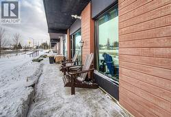 Exterior featuring horizontal wood-finish siding, a dark soffit, and large storefront windows - 
