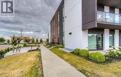 Modern architectural facade featuring white and dark gray paneling, brick accents, and large windows - 