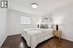 Hardwood-style flooring, a window with blinds, a flush-mount ceiling light, and white walls - 