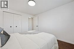 Wood-finish flooring, white walls, and a ceiling-mounted light fixture - 