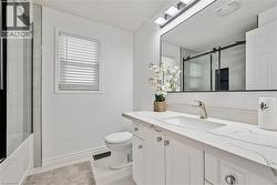White vanity with a single basin sink and a stone-finish countertop - 