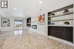 Polished tile flooring, built-in shelving with mirrored backing, recessed lighting, integrated electric fireplace, and sliding glass door access to the exterior - 
