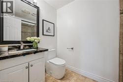 Vanity with a dark stone countertop, undermount sink, and a framed mirror - 