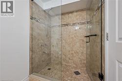 Walk-in shower with full height stone-finish tiling and decorative accent band - 