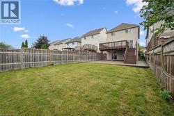 Expansive grassy lawn with a full-height wood privacy fence - 