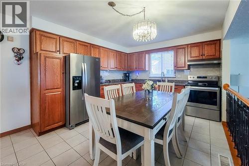 Kitchen featuring wood cabinetry, stainless steel appliances, and a tile floor - 276 Greencedar Drive, Hamilton, ON 