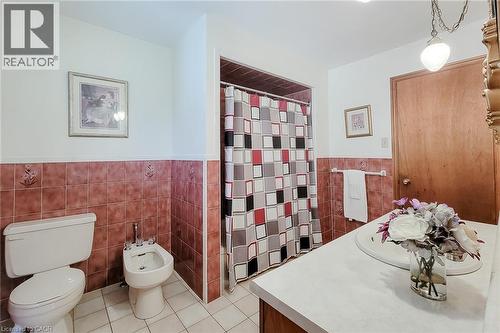 White tile flooring with coordinating red-toned tile wainscoting - 276 Greencedar Drive, Hamilton, ON 