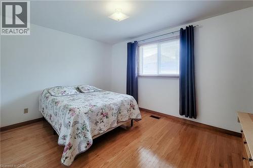Light-filled room featuring wood-finish flooring and a ceiling-mounted light fixture - 276 Greencedar Drive, Hamilton, ON 