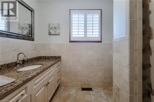 Bathroom vanity featuring a granite countertop, undermount sink, and brushed nickel faucet - 276 Greencedar Drive, Hamilton, ON 