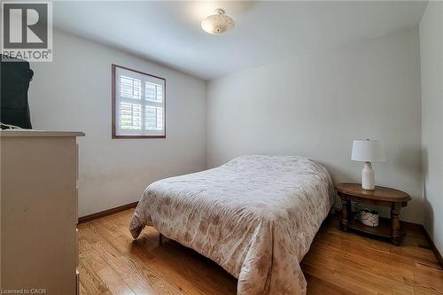 Hardwood flooring, neutral wall tones, window with plantation shutters, and a ceiling-mounted light fixture - 276 Greencedar Drive, Hamilton, ON 