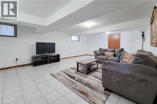 Spacious room featuring white tile flooring, white walls, and a recessed ceiling area - 276 Greencedar Drive, Hamilton, ON 