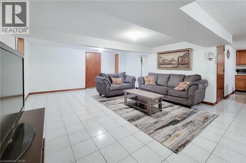 Recessed lighting illuminates this expansive space featuring white tile flooring, wood-finish trim, and natural wood doors - 276 Greencedar Drive, Hamilton, ON 