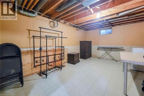 Unfinished basement with exposed ceiling joists, light-colored walls, and tiled flooring - 276 Greencedar Drive, Hamilton, ON 