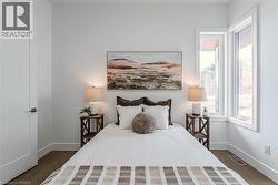Wood-finish flooring, white walls, and a solid core door with contemporary hardware - 