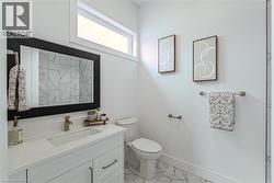White vanity with integrated sink, brushed nickel faucet, and a large framed mirror - 