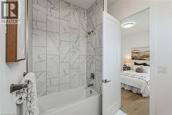 Bathtub with tiled surround, wall-mounted showerhead, and coordinating faucet - 