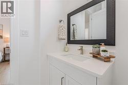 White single-sink vanity with white countertop, brushed nickel faucet, and a large rectangular mirror with a textured black frame - 