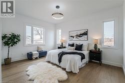 Recessed lighting, wood-finish flooring, multiple windows, and a contemporary ceiling fixture - 
