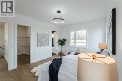 Recessed lighting, wood-finish flooring, white trim, and a built-in closet system - 