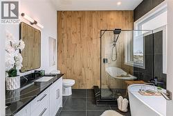 Dual vanity with undermount sinks, black countertop, a walk-in shower with clear glass enclosure, a freestanding bathtub, and wood-panel accent wall - 