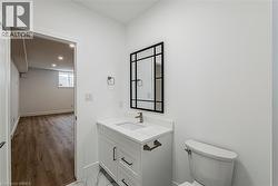 White vanity with a quartz countertop, undermount sink, and dark-framed mirror - 