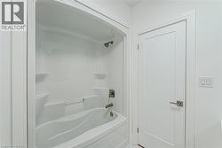 White acrylic tub and shower combination with brushed nickel fixtures - 