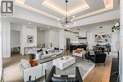 Coffered ceiling with recessed lighting and a contemporary chandelier - 