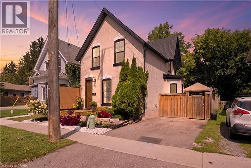 Brick exterior with dark-trimmed windows, a front porch, and a dedicated driveway - 57 Terrace Hill Street, Brantford, ON 